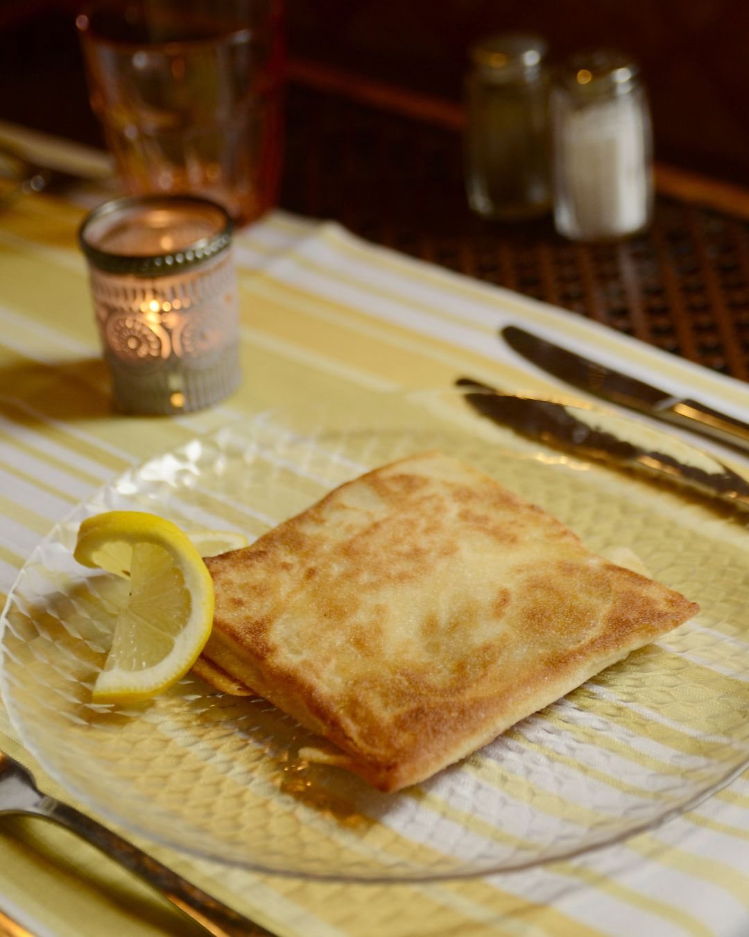 Une brik dorée, servie avec un citron