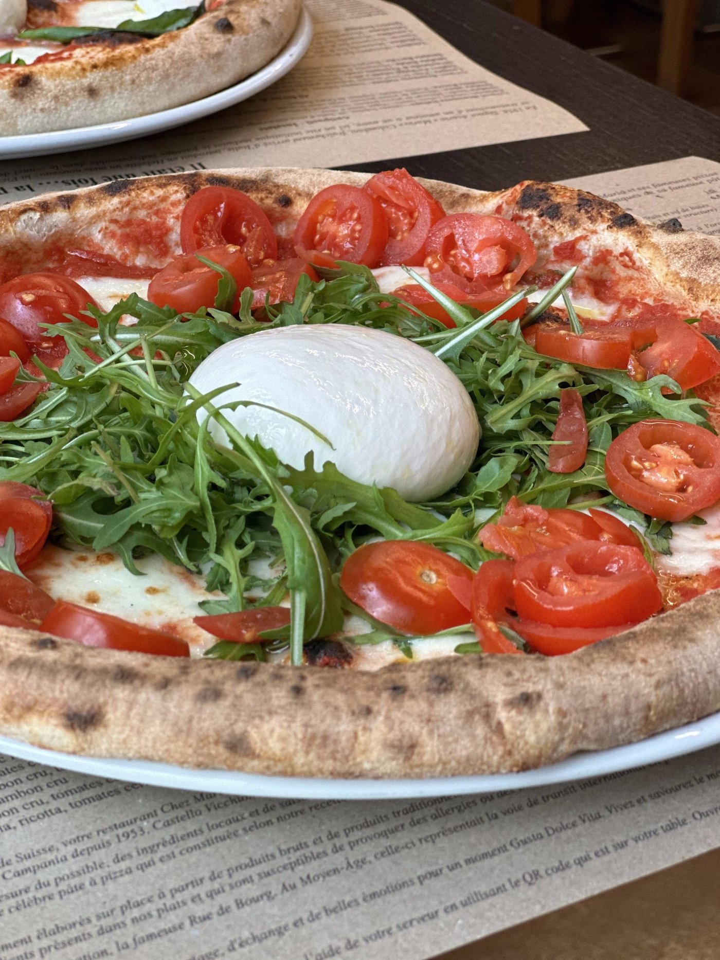 Pizza à la burrata, roquette et tomates cerises, une création des pizzaïoli