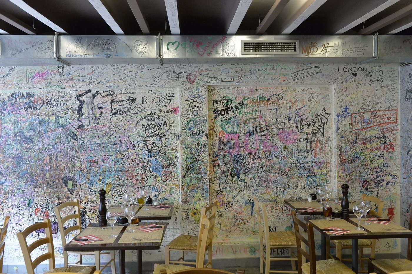 Le mur de graffitis et les tables dressées de la salle