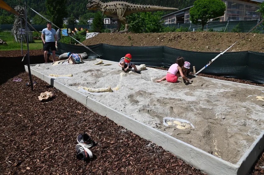 Enfants qui creusent le sable lors des fouilles archéologiques à Dino World