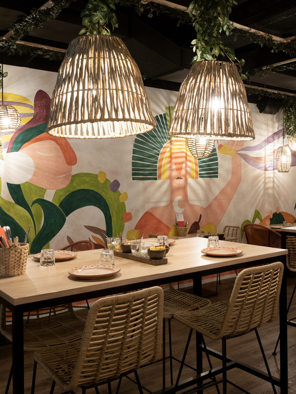 Une salle du restaurant devant la fresque murale colorée