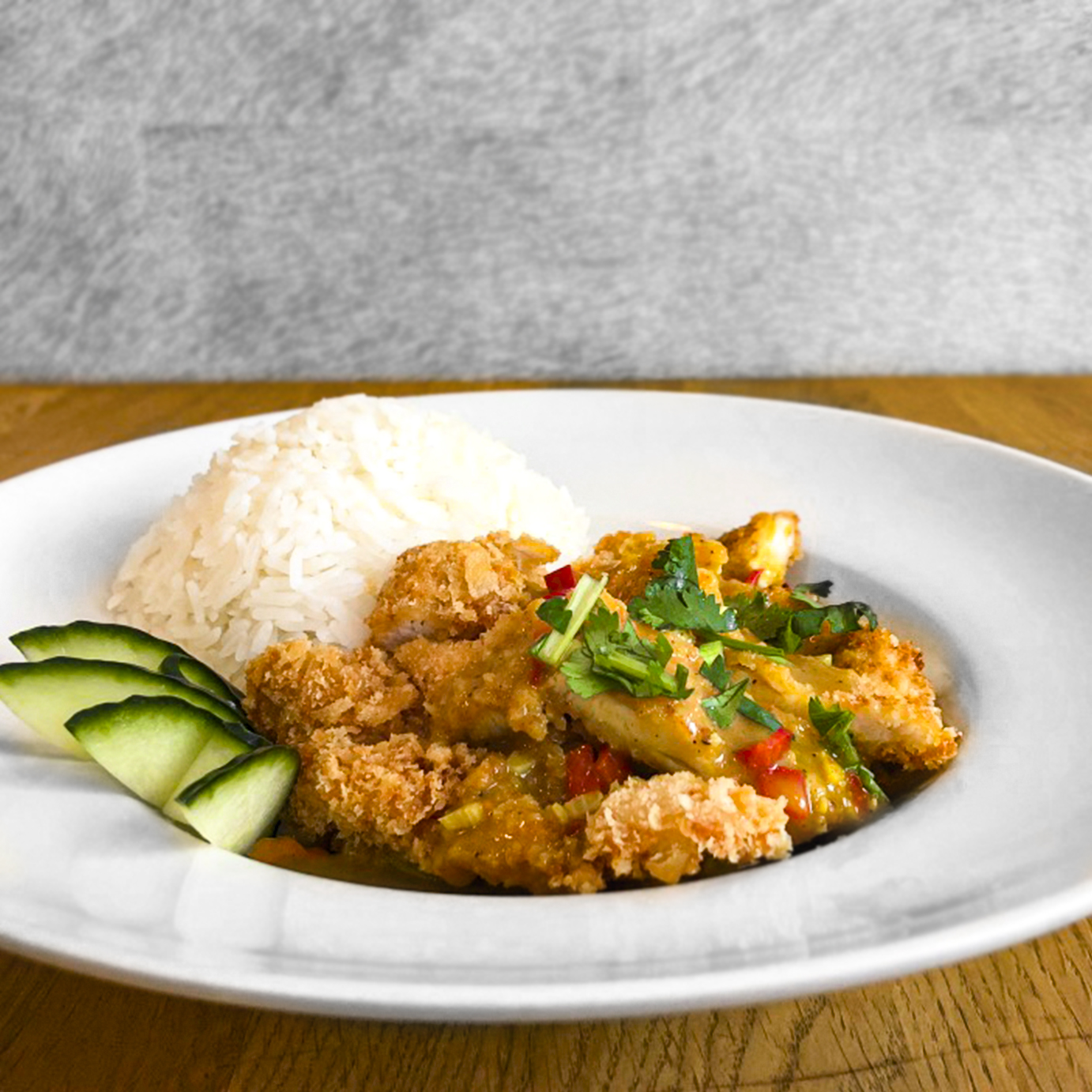 Poulet croustillant au curry, riz parfumé et coriandre, servi chez Wawa's Asian Kitchen à Lausanne