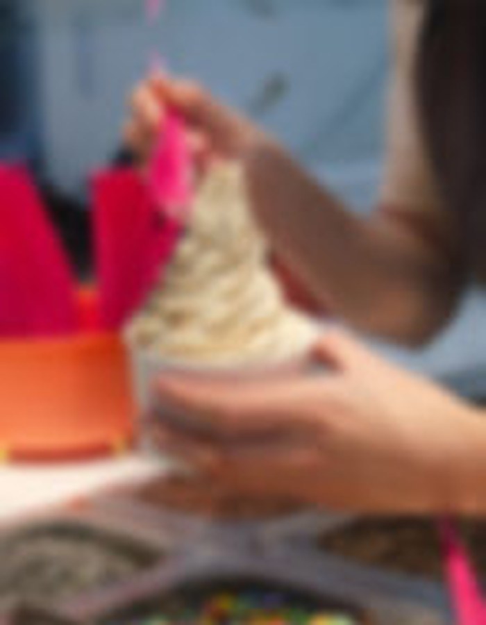 Préparation d'un yogourt glacé Yogo avec toppings